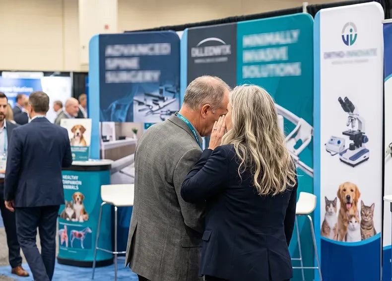 A department head pulling Dr. Dench aside at a conference