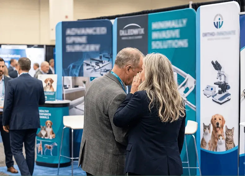A department head taking Dr. Dench aside at a veterinary conference